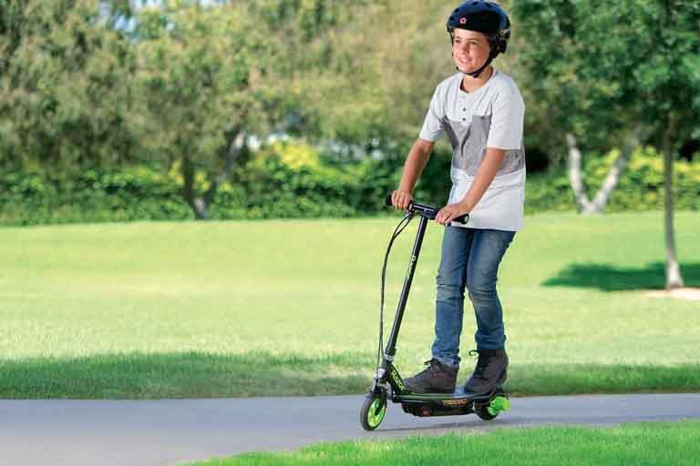 kid enjoys riding on a razor a5 lux scooter in a park