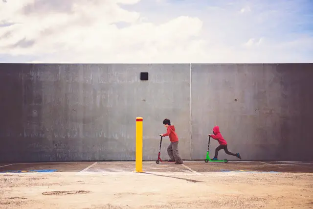 Two boys playing kick scooter